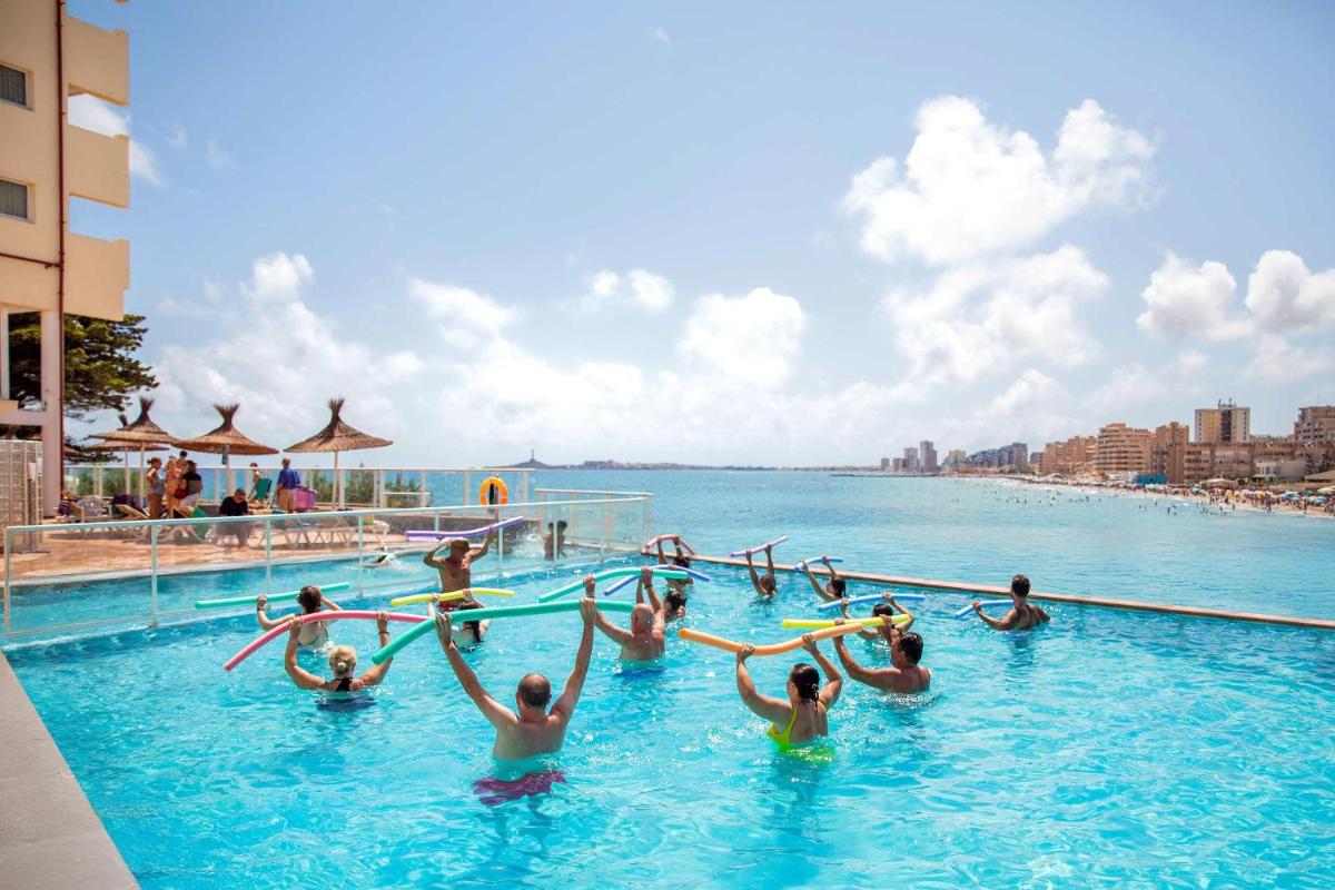 Un grupo de personas en el agua de una piscina. en Hotel Servigroup Galua, en La Manga del Mar Menor