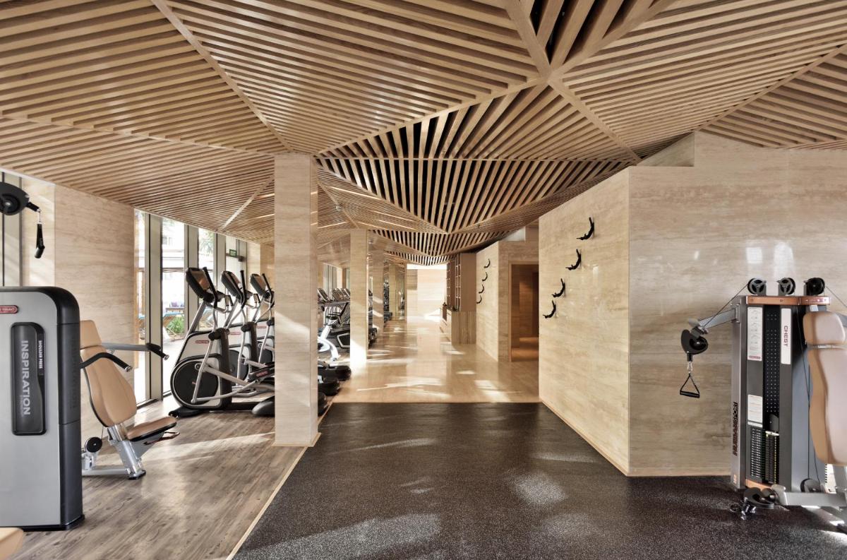 a gym with wooden ceilings and exercise equipment at JW Marriott Mumbai Sahar Airport in Mumbai a gym with wooden ceilings and exercise equipment at JW Marriott Mumbai Sahar Airport in Mumbai