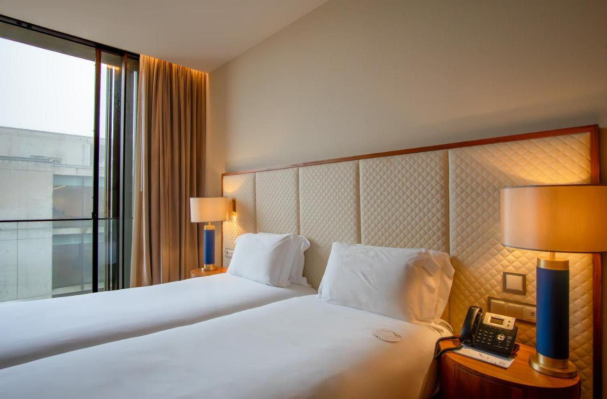 Uma cama ou camas num quarto em Boeira Garden Hotel Porto Gaia, Curio Collection by Hilton
