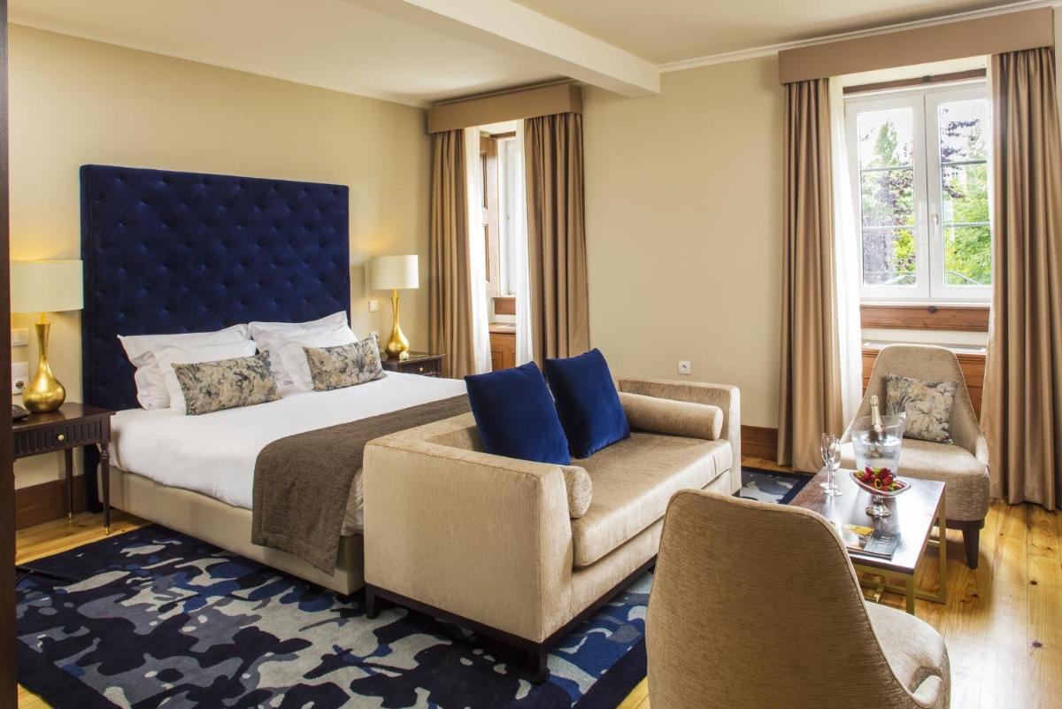 um quarto com uma cama, um sofá e uma cadeira em Hotel Quinta das Lagrimas - Small Luxury Hotels em Coimbra mais 47 fotografias