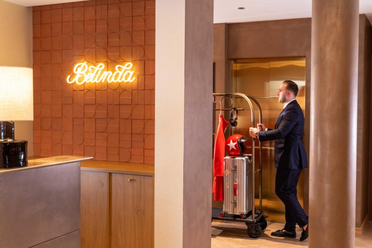 un homme en costume debout devant un restaurant dans l'établissement Belinda Hôtel & Spa, à Paris 70 autres photos