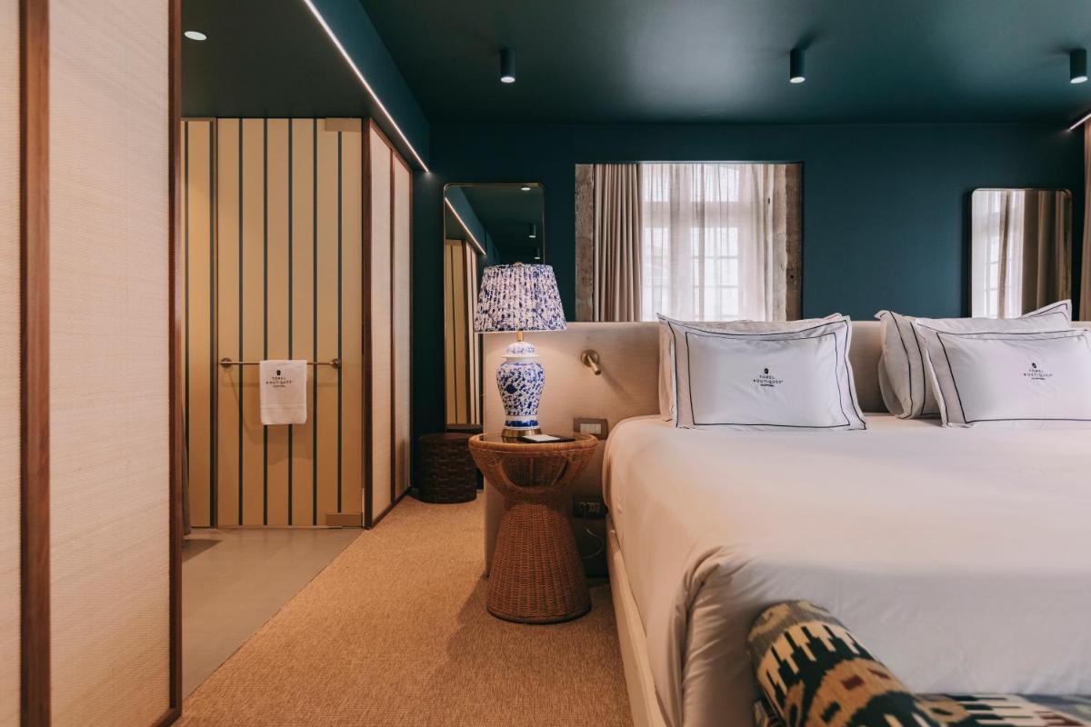 um quarto com uma cama e um abajur sobre uma mesa em Torel Terra Brava em Angra do Heroísmo