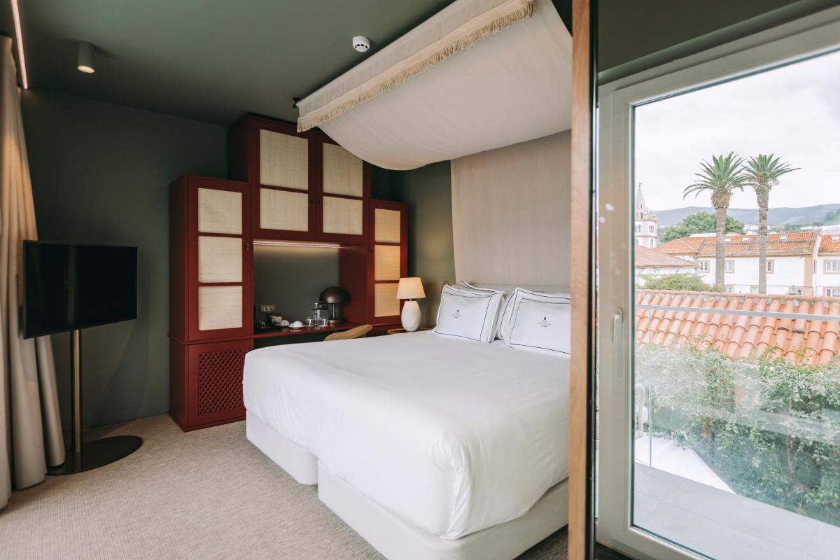 um quarto com uma grande cama branca e uma janela em Torel Terra Brava em Angra do Heroísmo mais 107 fotografias