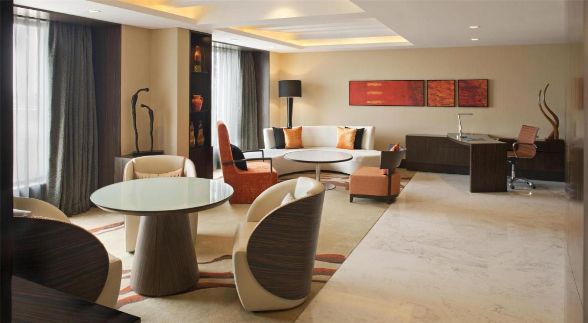 a living room with tables and chairs and a couch at Radisson Blu Hotel Amritsar in Amritsar