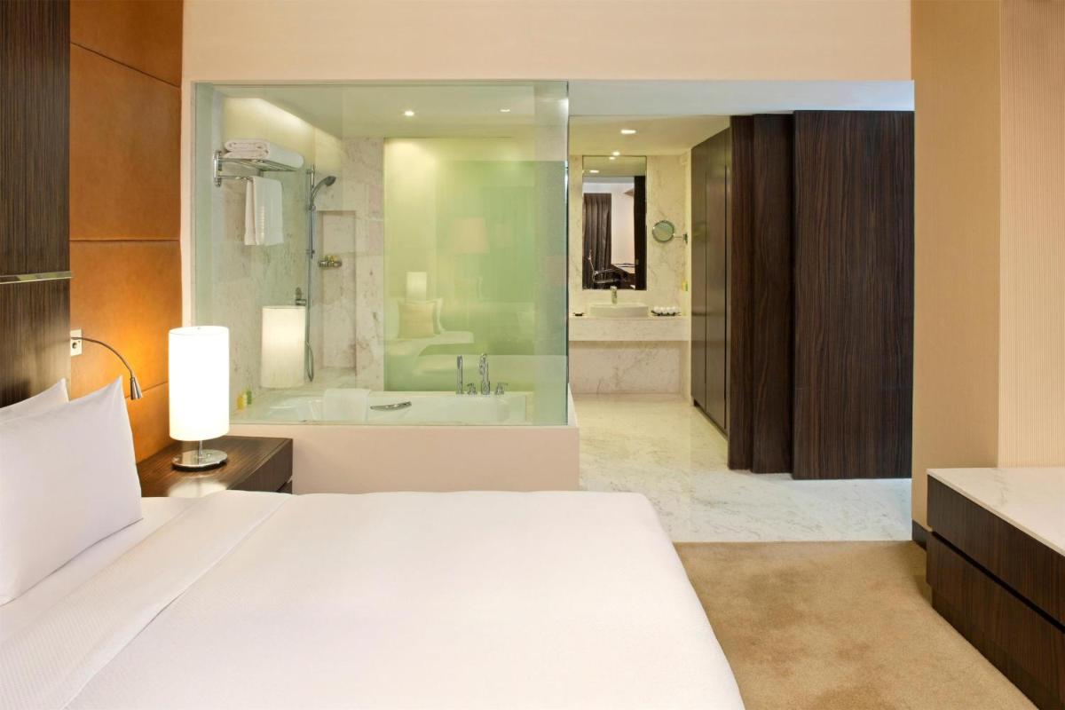 a bedroom with a large bed and a bath tub at Radisson Blu Hotel Amritsar in Amritsar