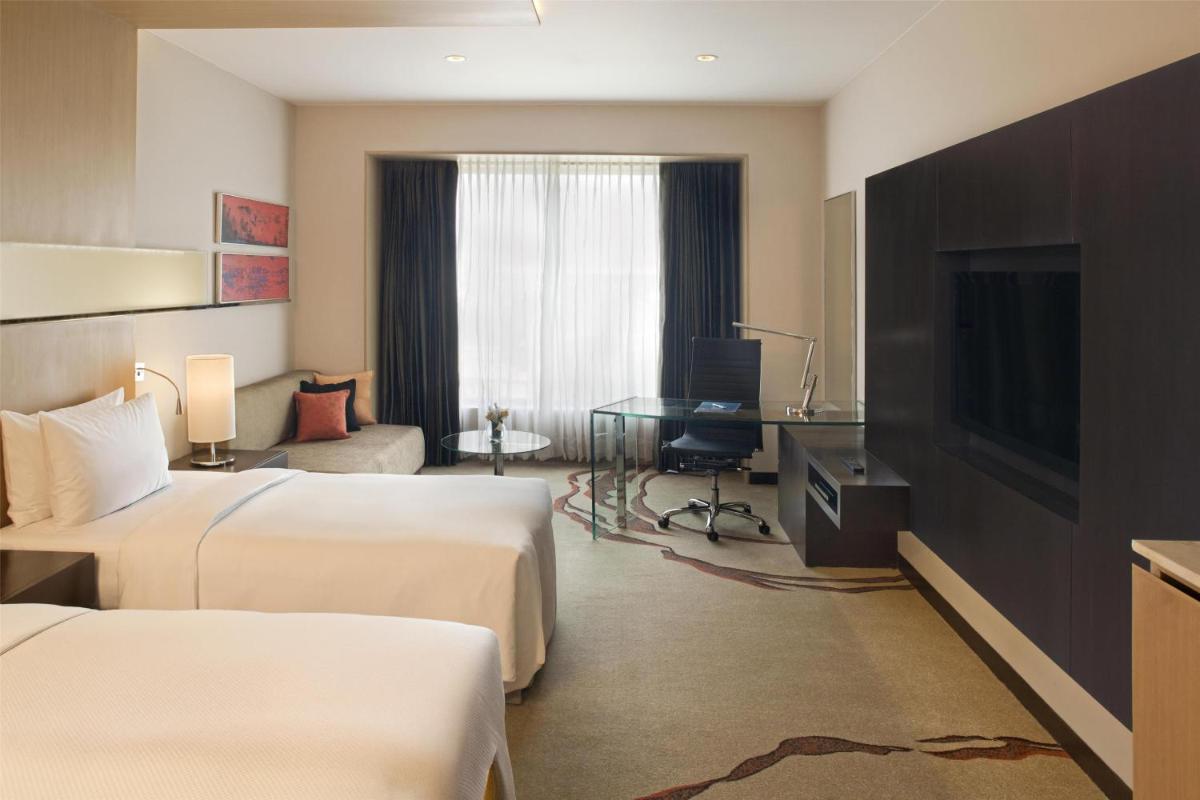 a hotel room with two beds and a desk at Radisson Blu Hotel Amritsar in Amritsar