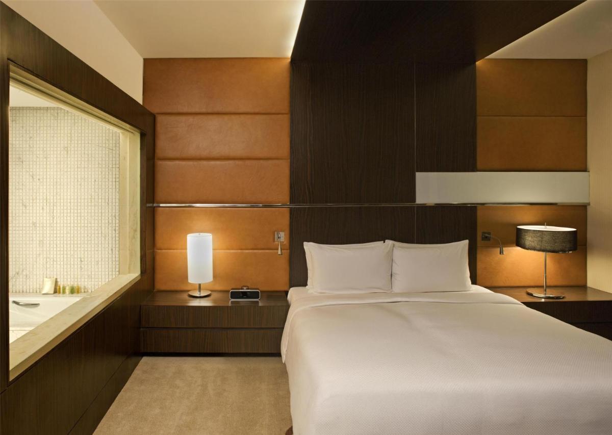 a bedroom with a large white bed and a window at Radisson Blu Hotel Amritsar in Amritsar