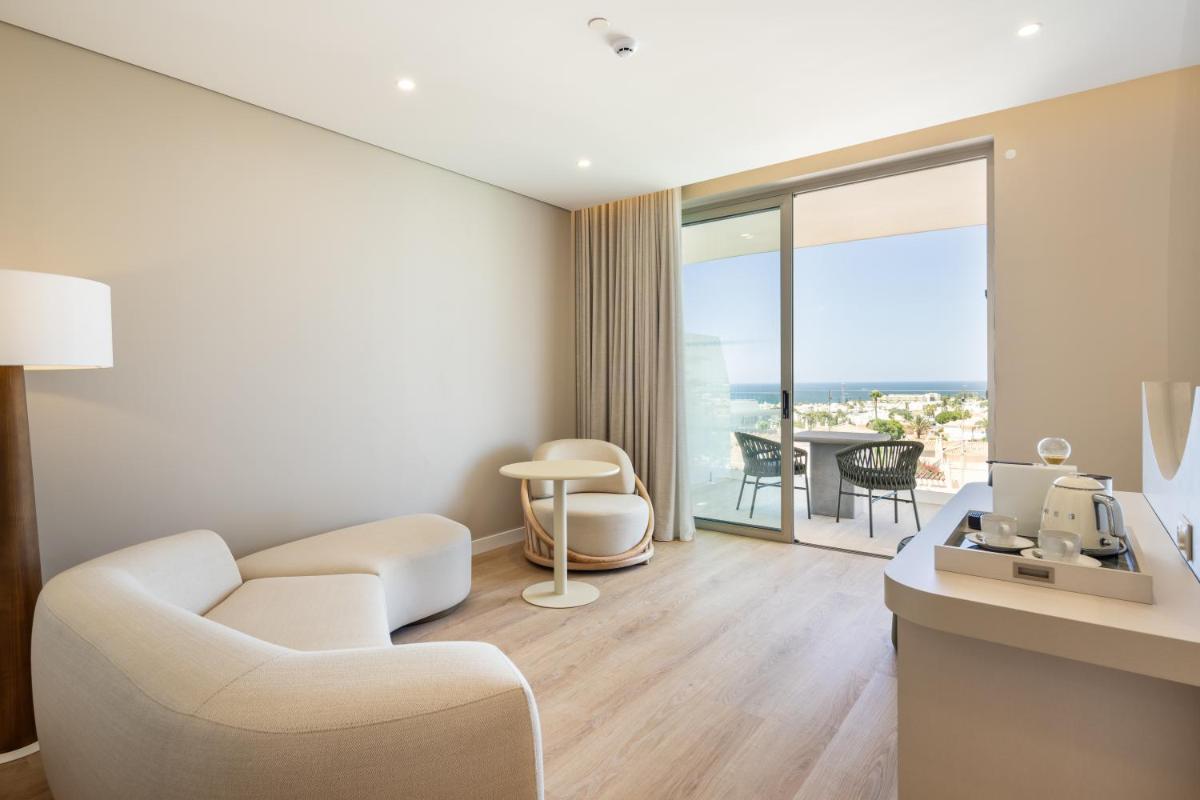 uma sala de estar com um sofá branco e uma mesa em Castelo Suites Hotel em Albufeira