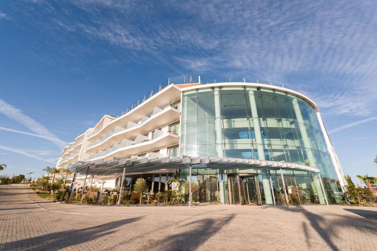 um grande edifício de vidro com muitas janelas em Castelo Suites Hotel em Albufeira