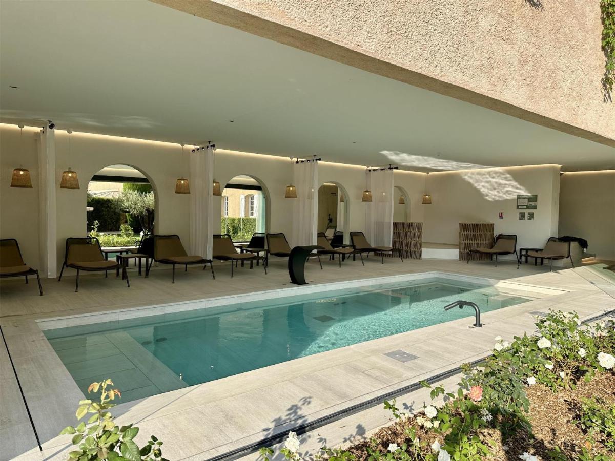 - une piscine dans une maison avec des chaises et des tables dans l'établissement La Bastide du Calalou Hotel & Spa, BW Signature Collection, à Moissac-Bellevue