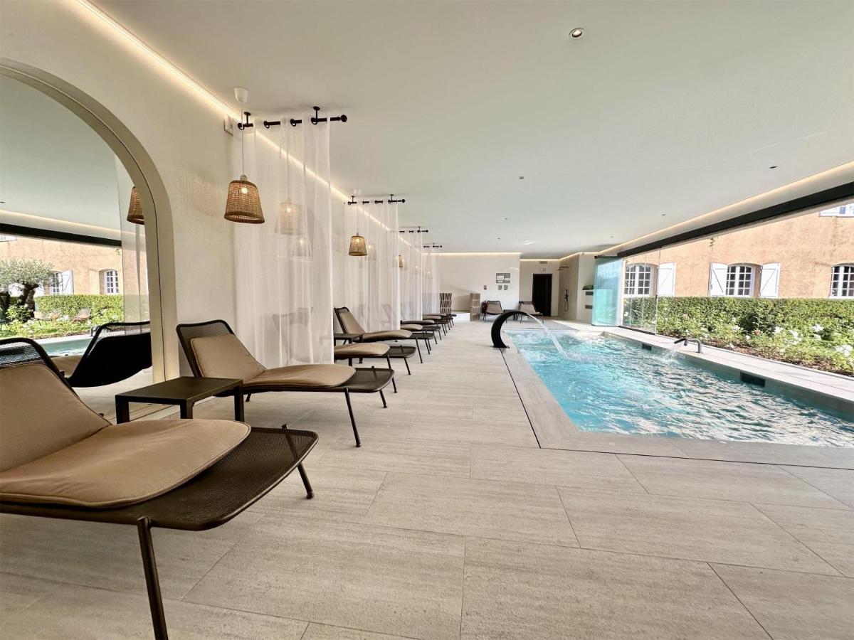 une piscine dans un bâtiment avec des chaises et une piscine dans l'établissement La Bastide du Calalou Hotel & Spa, BW Signature Collection, à Moissac-Bellevue 106 autres photos