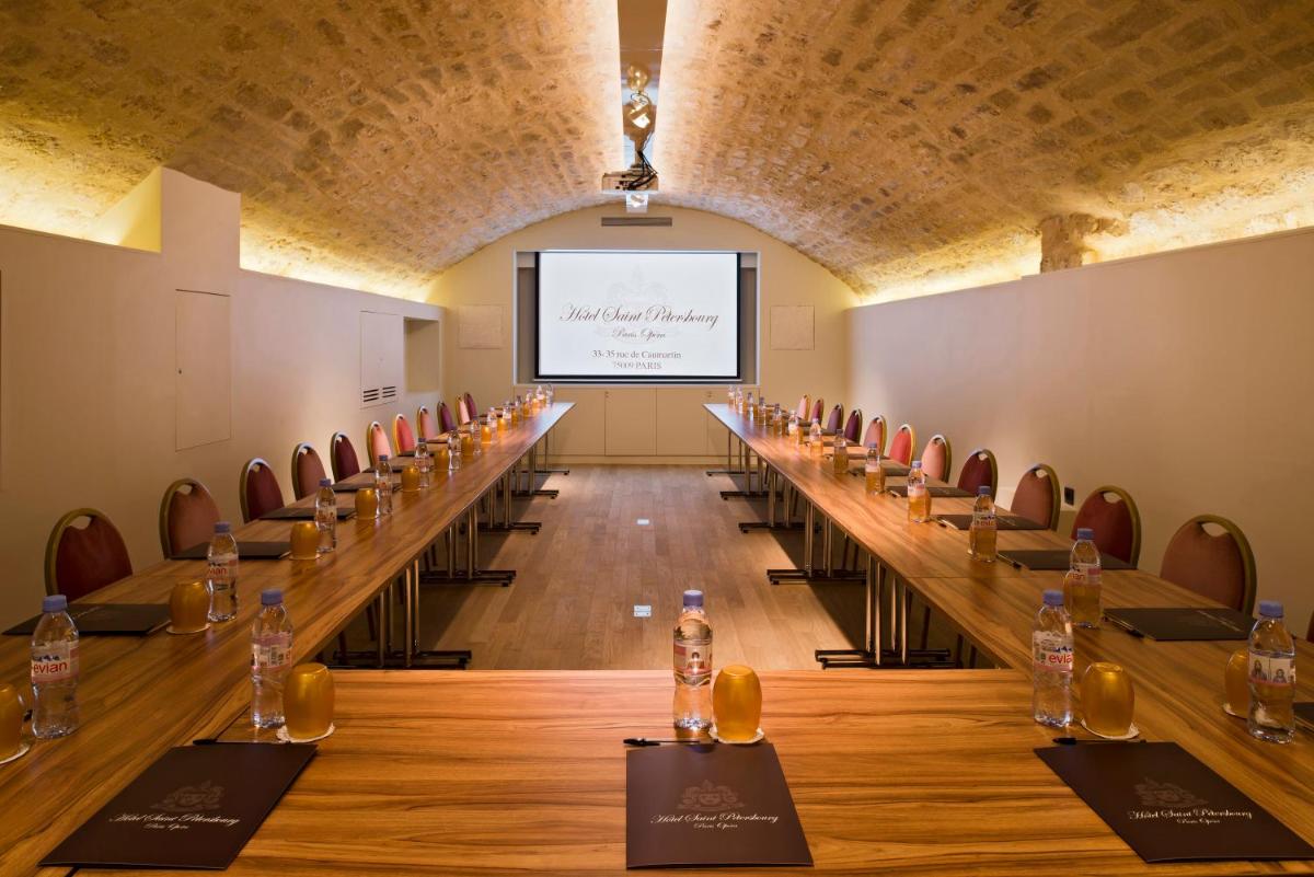 - une salle de conférence avec une grande table et des bouteilles de vin dans l'établissement Hôtel Saint-Pétersbourg Opéra & Spa, à Paris