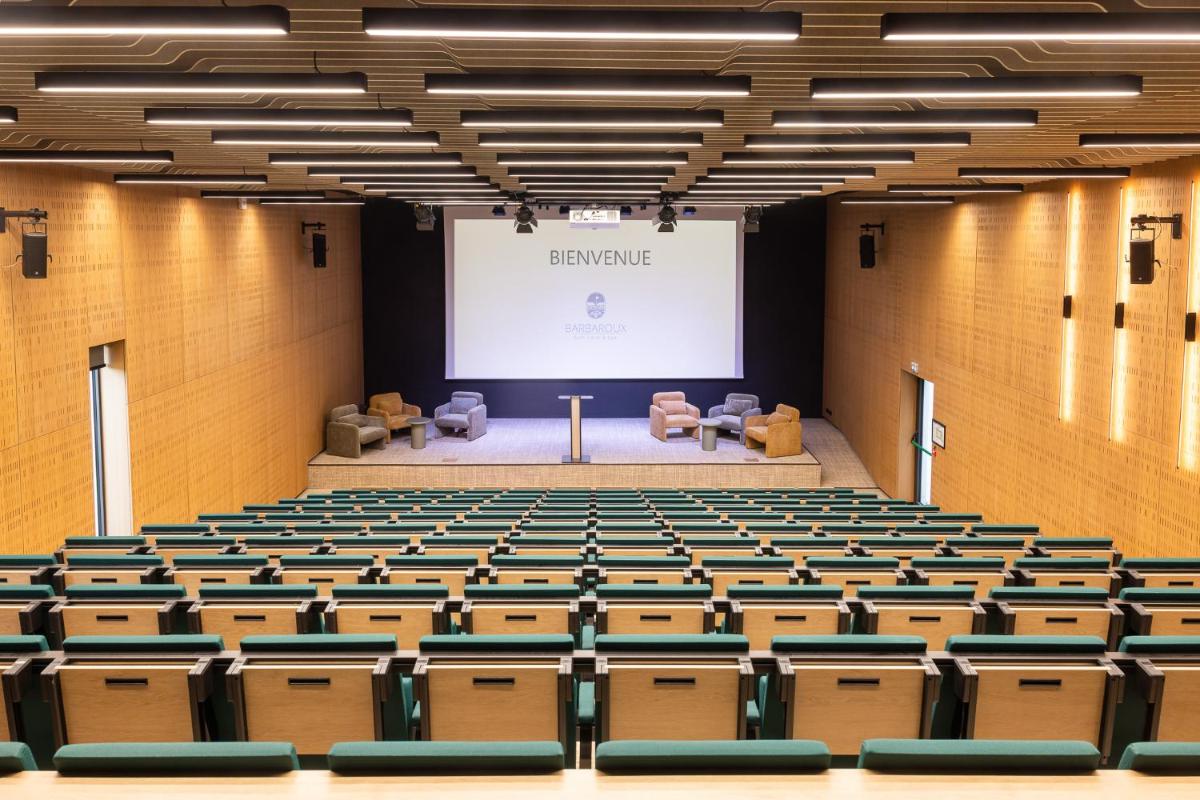 un amphithéâtre vide avec un écran et des chaises dans l'établissement Mercure Brignoles Golf de Barbaroux & Spa, à Brignoles 167 autres photos