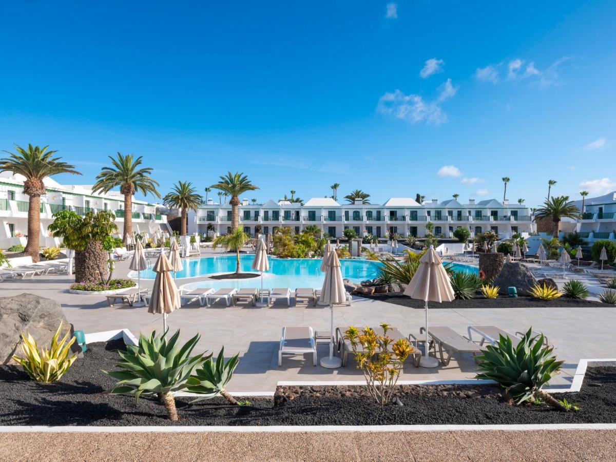 un resort con piscina y palmeras en MYND Yaiza, en Playa Blanca