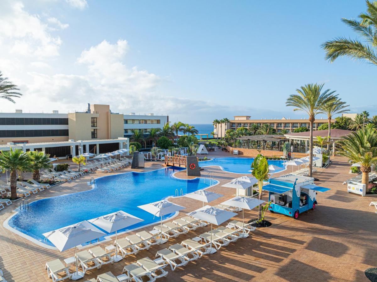 una vista aérea de una piscina del complejo con tumbonas en Iberostar Waves Gaviotas Park, en Morro del Jable