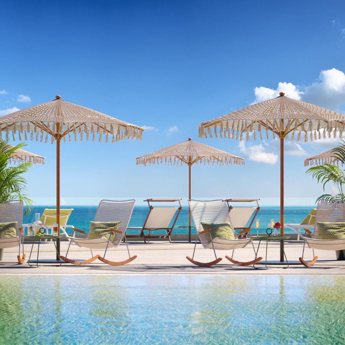 Un grupo de sillas y sombrillas junto a una piscina. en Iberostar Selection Fuerteventura Palace, en Morro del Jable