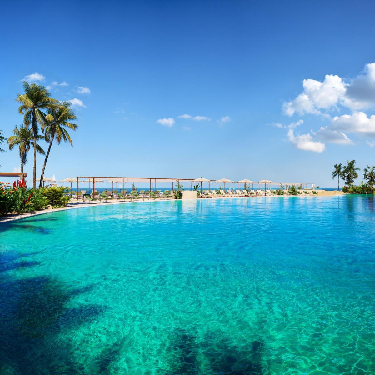 una gran piscina de agua azul con palmeras en Iberostar Selection Fuerteventura Palace, en Morro del Jable