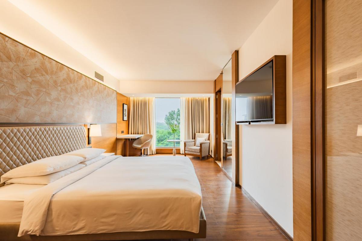 a hotel room with a bed and a television at Hyatt Pune in Pune
