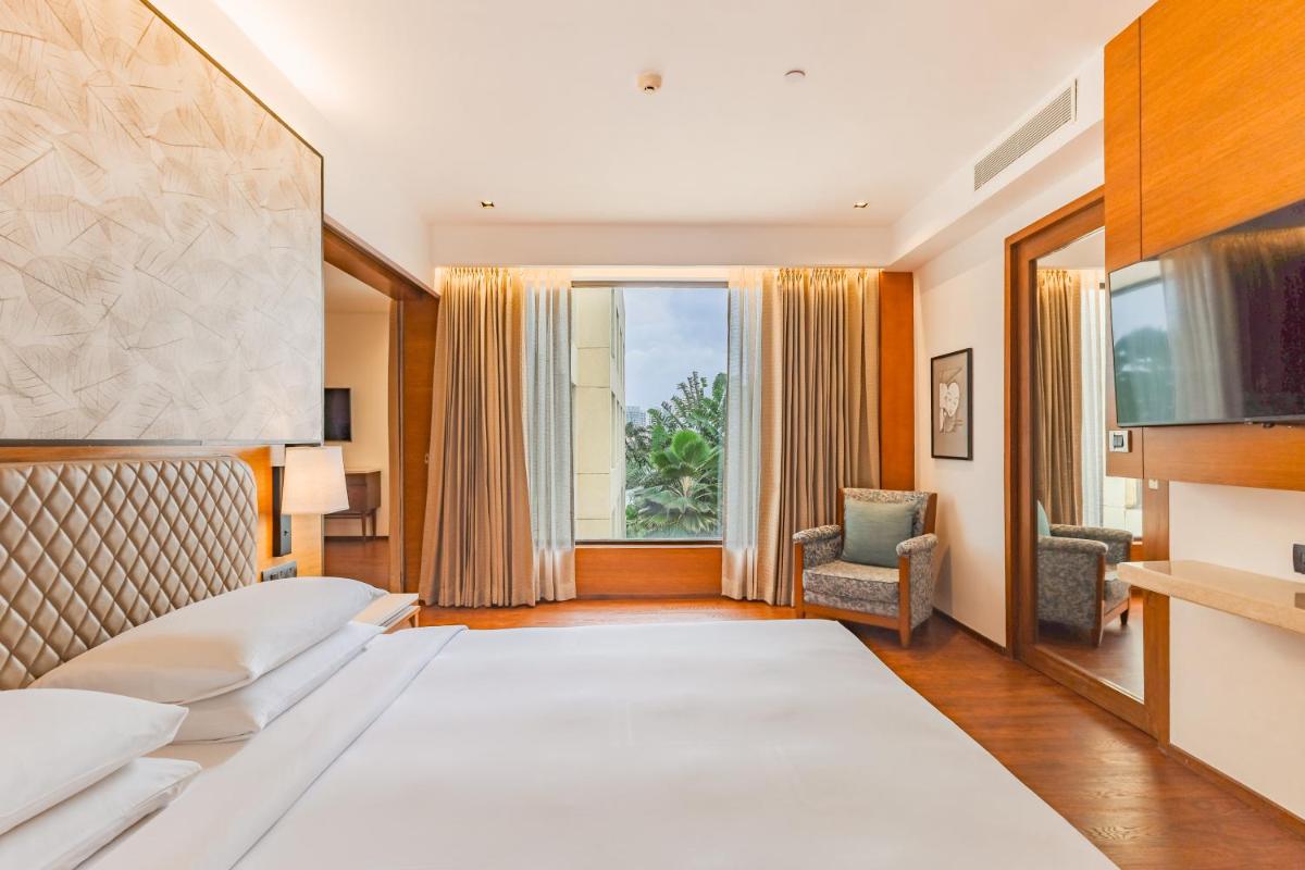a hotel room with a large bed and a window at Hyatt Pune in Pune