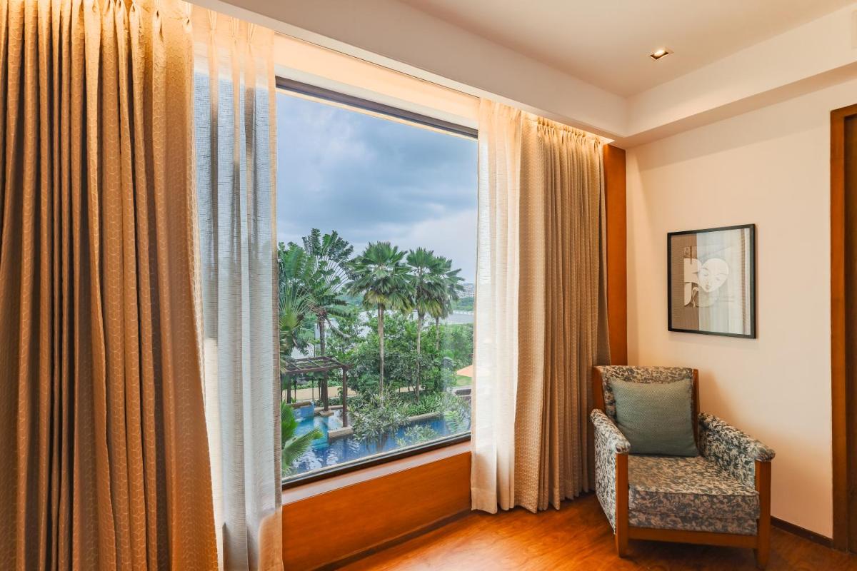 a room with a window and a chair with a view at Hyatt Pune in Pune