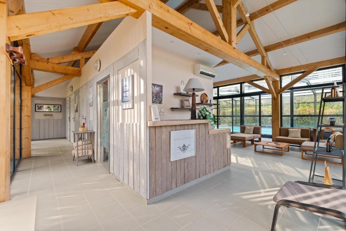 un grand salon avec des plafonds en bois et un bar dans l'établissement Hotel Saint Paul, à Noirmoutier-en-l'lle