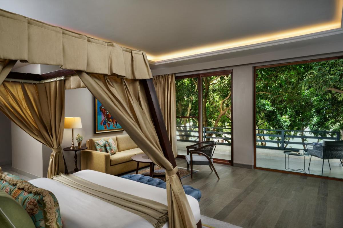 a hotel room with a bed and a balcony at Anand Kashi by the Ganges Rishikesh - IHCL Seleqtions in Rishīkesh