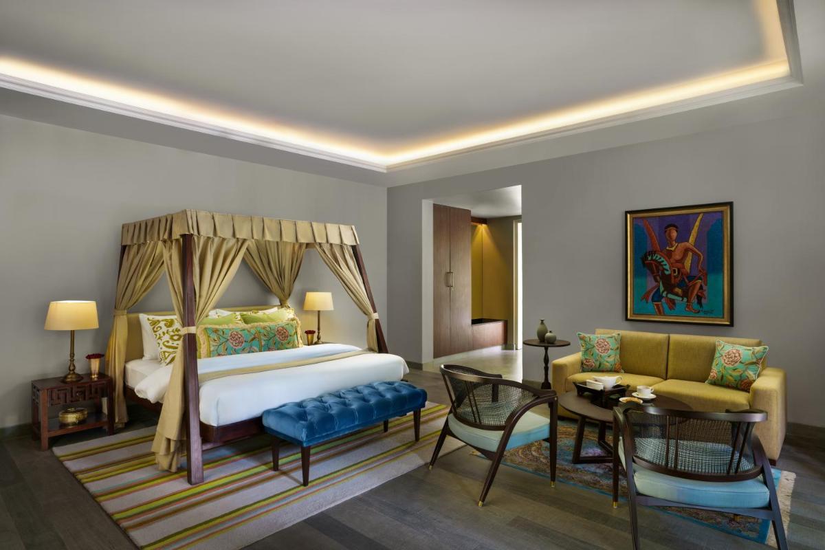a hotel room with a bed and a dining room at Anand Kashi by the Ganges Rishikesh - IHCL Seleqtions in Rishīkesh