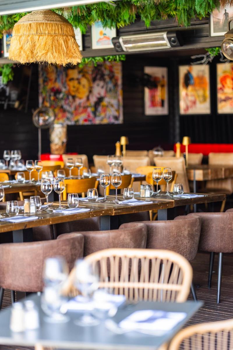 un restaurant avec des tables et des chaises avec des verres à vin dans l'établissement Les Terrasses de Saumur - Hôtel & Appartements - Restaurant & Spa (Logis), à Saumur