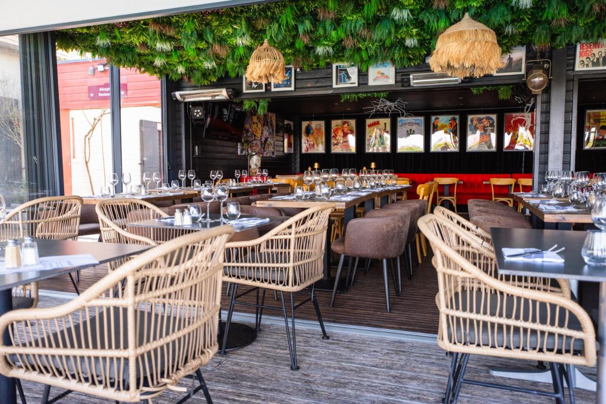 un restaurant avec des tables et des chaises dans une salle dans l'établissement Les Terrasses de Saumur - Hôtel & Appartements - Restaurant & Spa (Logis), à Saumur 80 autres photos