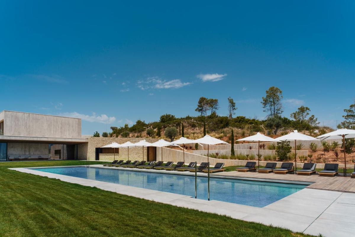 una piscina con sillas y sombrillas en La Galiana Golf Resort - Adults Only, en Barraca de Aguas Vivas