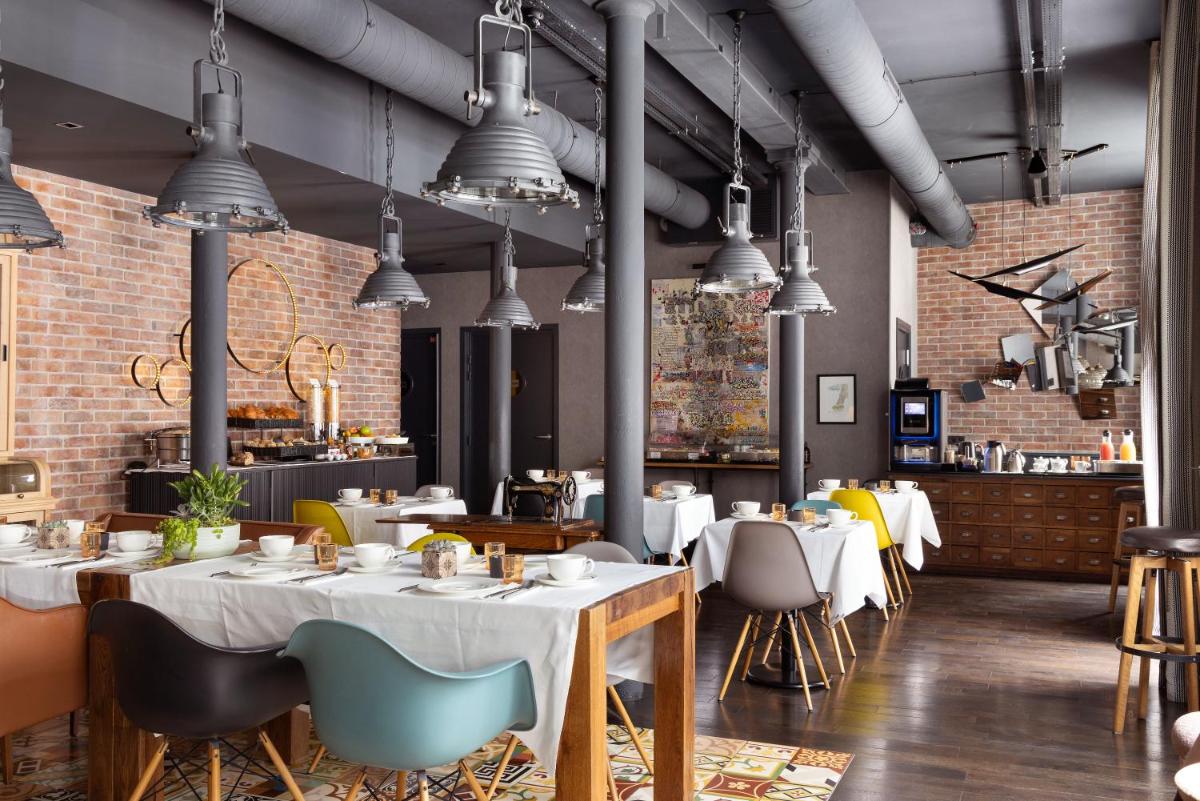 un restaurant avec des tables et des chaises et des murs en briques apparentes dans l'établissement Hôtel Fabric, à Paris