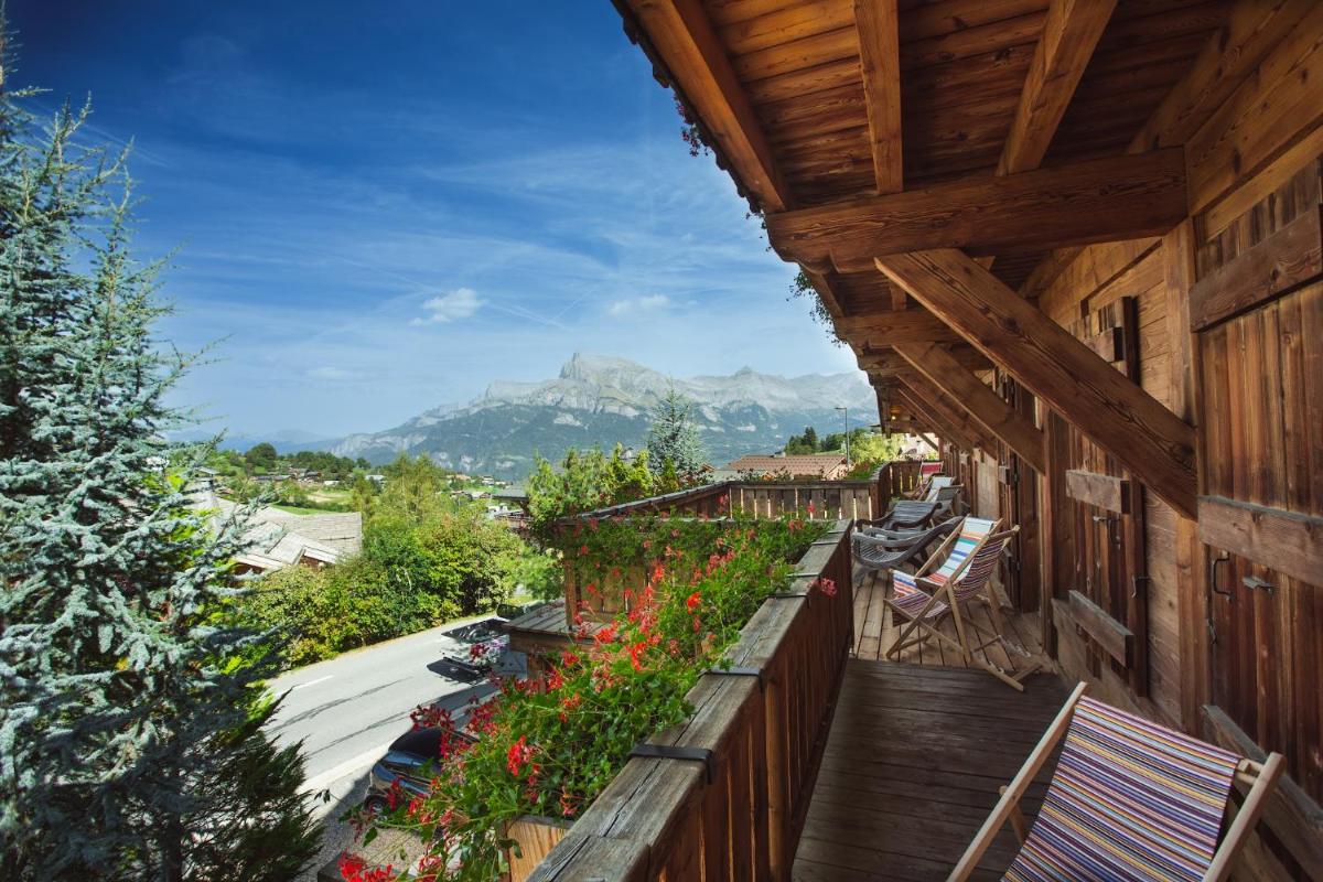 - un balcon d'une maison ornée de fleurs dans l'établissement Magic Megève Bois, à Demi-Quartier