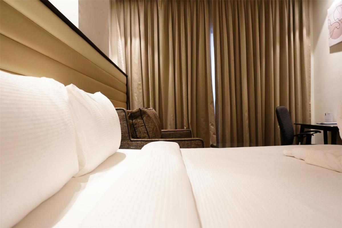 a hotel room with a bed and chairs and curtains at Hilton Garden Inn Pune Hinjawadi in Pune