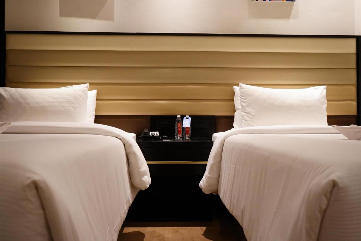 two beds in a hotel room with white sheets at Hilton Garden Inn Pune Hinjawadi in Pune