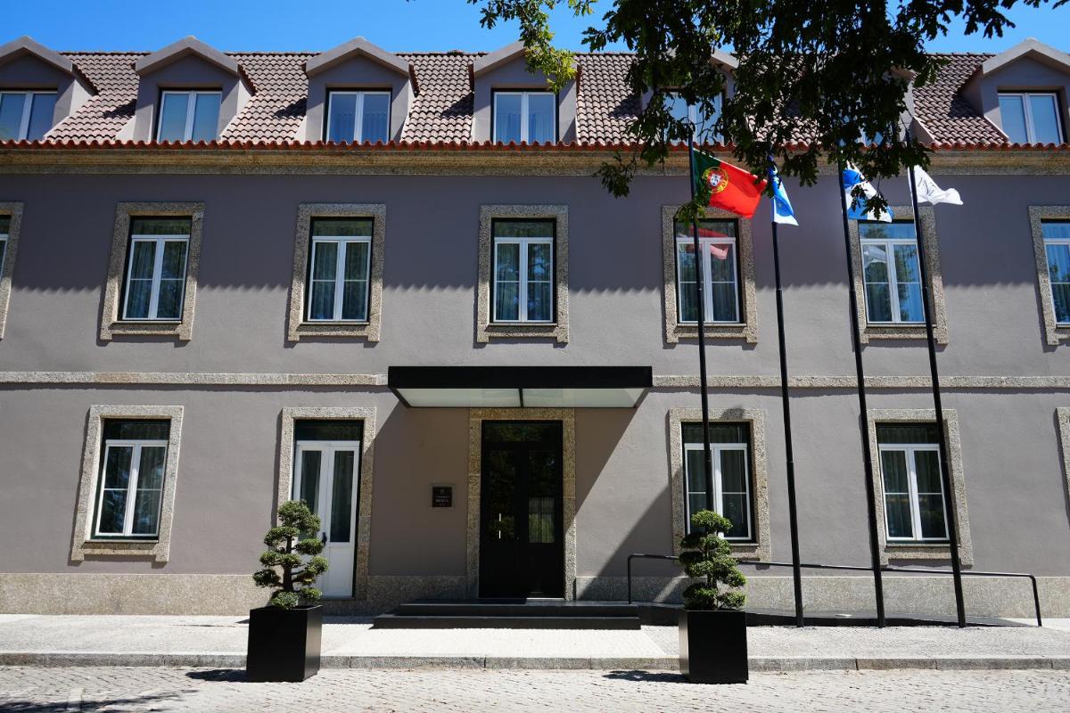 um prédio com duas bandeiras na frente. em The Lince Braga em Braga