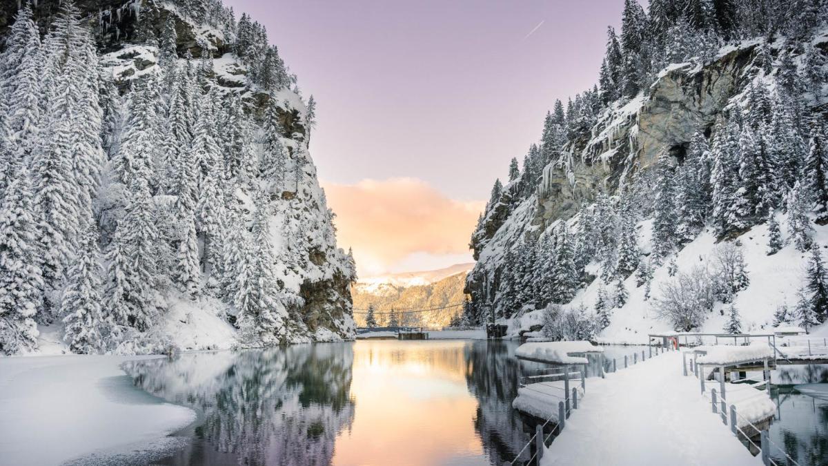 une rivière couverte de neige avec une montagne dans l'établissement Ecrin Blanc Resort Courchevel - Aquapark, à Courchevel