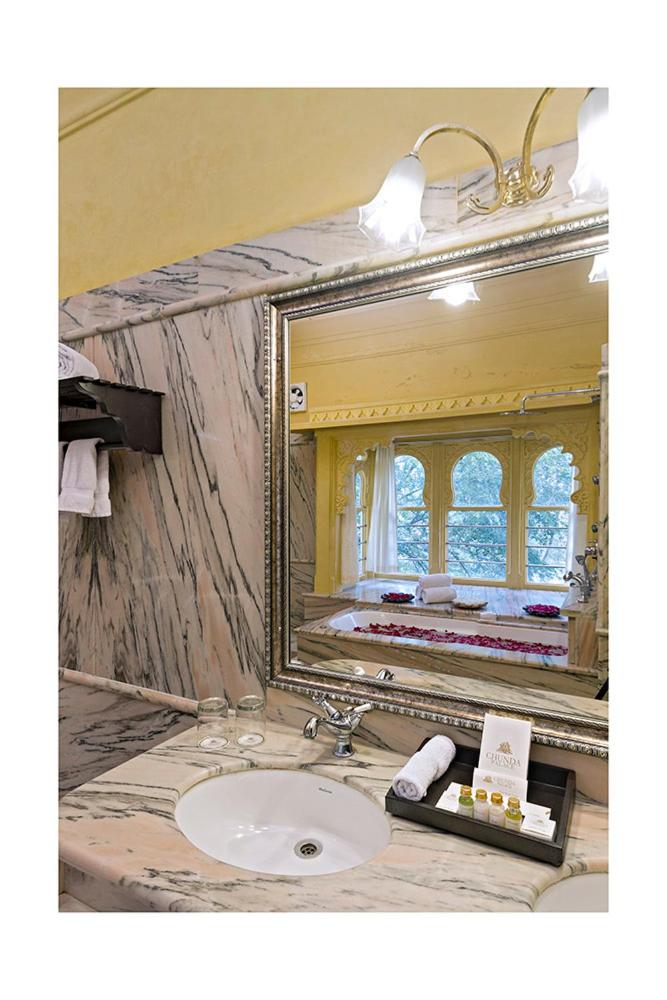 a bathroom with a sink and a mirror at Chunda Palace in Udaipur