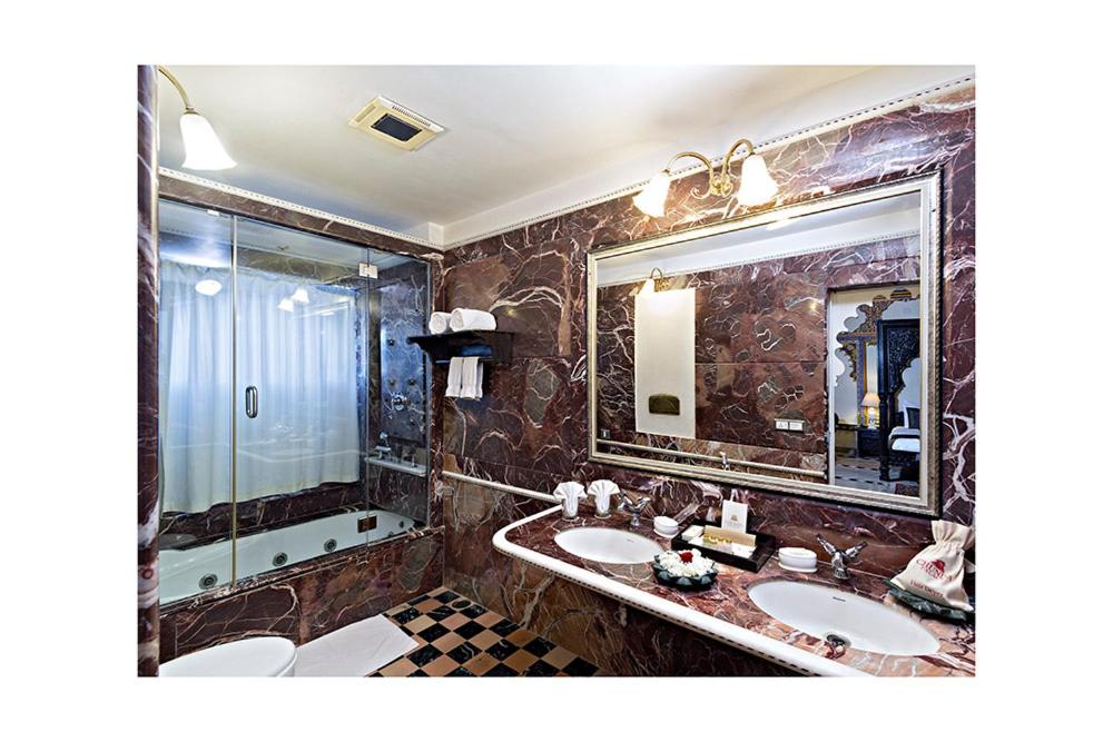 a bathroom with two sinks and a large mirror at Chunda Palace in Udaipur