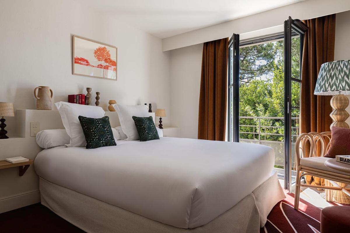 un grand lit blanc dans une chambre avec une fenêtre dans l'établissement Hôtel Maison Chiberta, à Anglet 27 autres photos