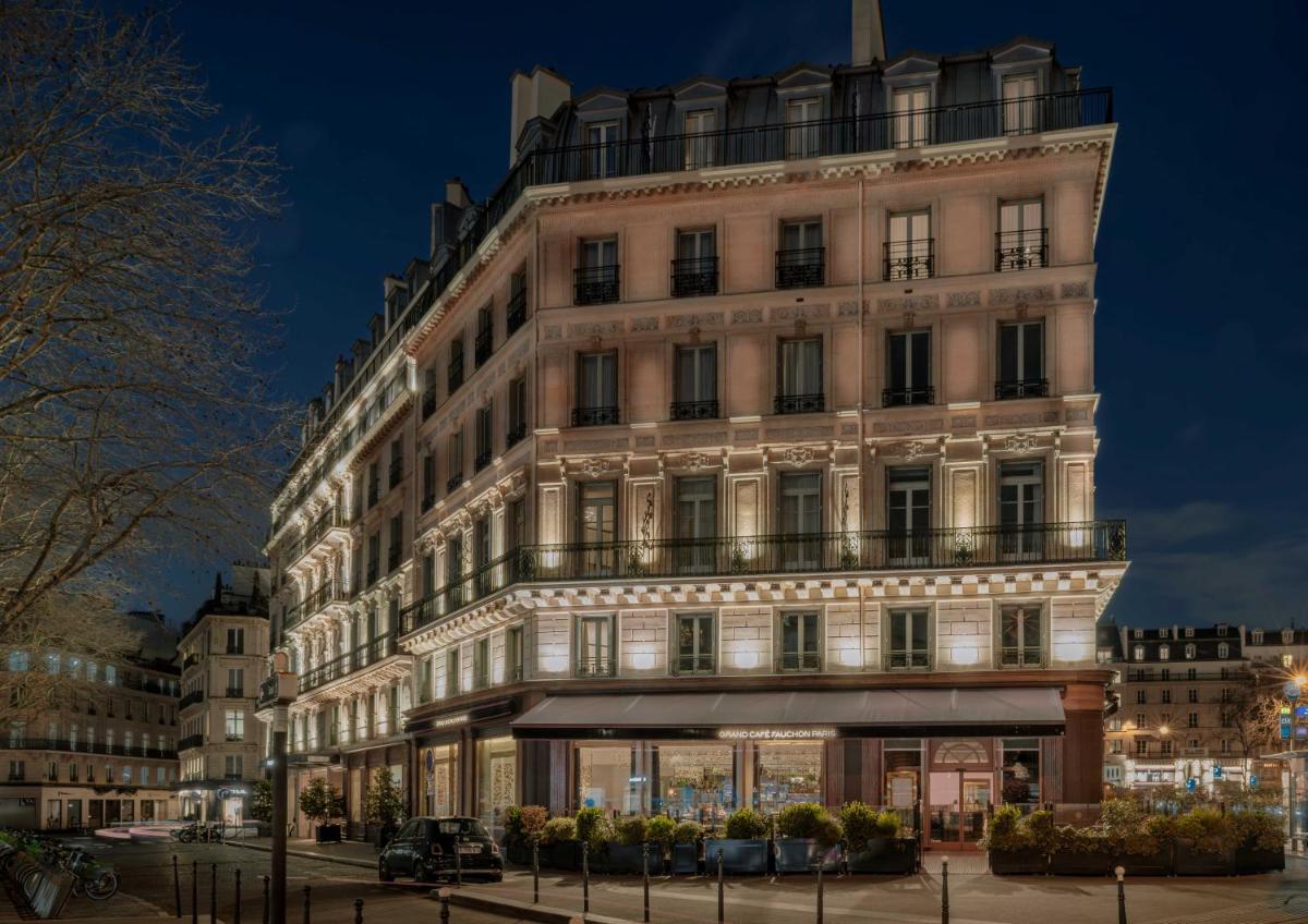 un grand bâtiment blanc avec beaucoup de fenêtres dans l'établissement Fauchon l'Hôtel Paris, à Paris