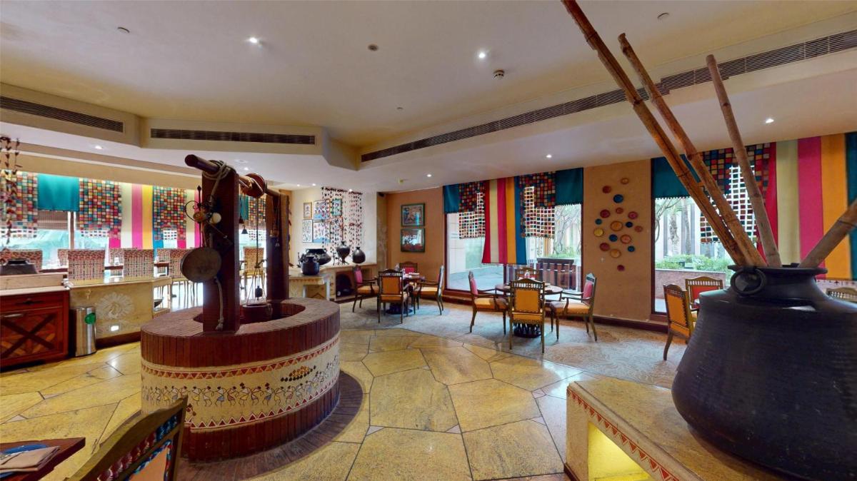 a lobby with a room with tables and chairs at Radisson Blu Hotel, Nagpur in Nagpur