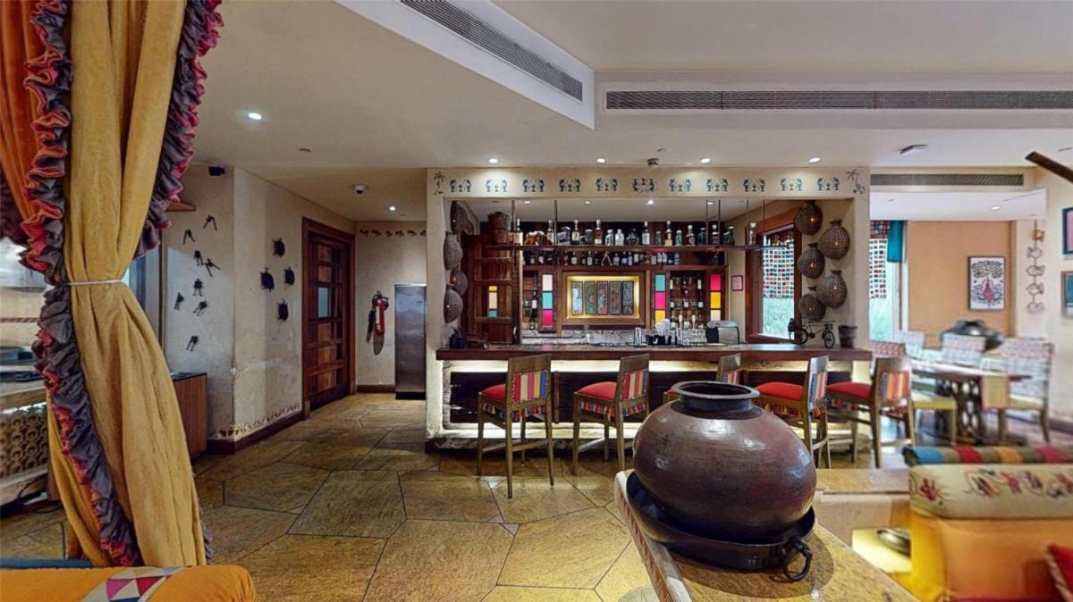 a living room with a bar with a table and chairs at Radisson Blu Hotel, Nagpur in Nagpur
