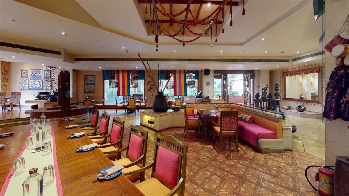 a restaurant with tables and chairs in a large room at Radisson Blu Hotel, Nagpur in Nagpur