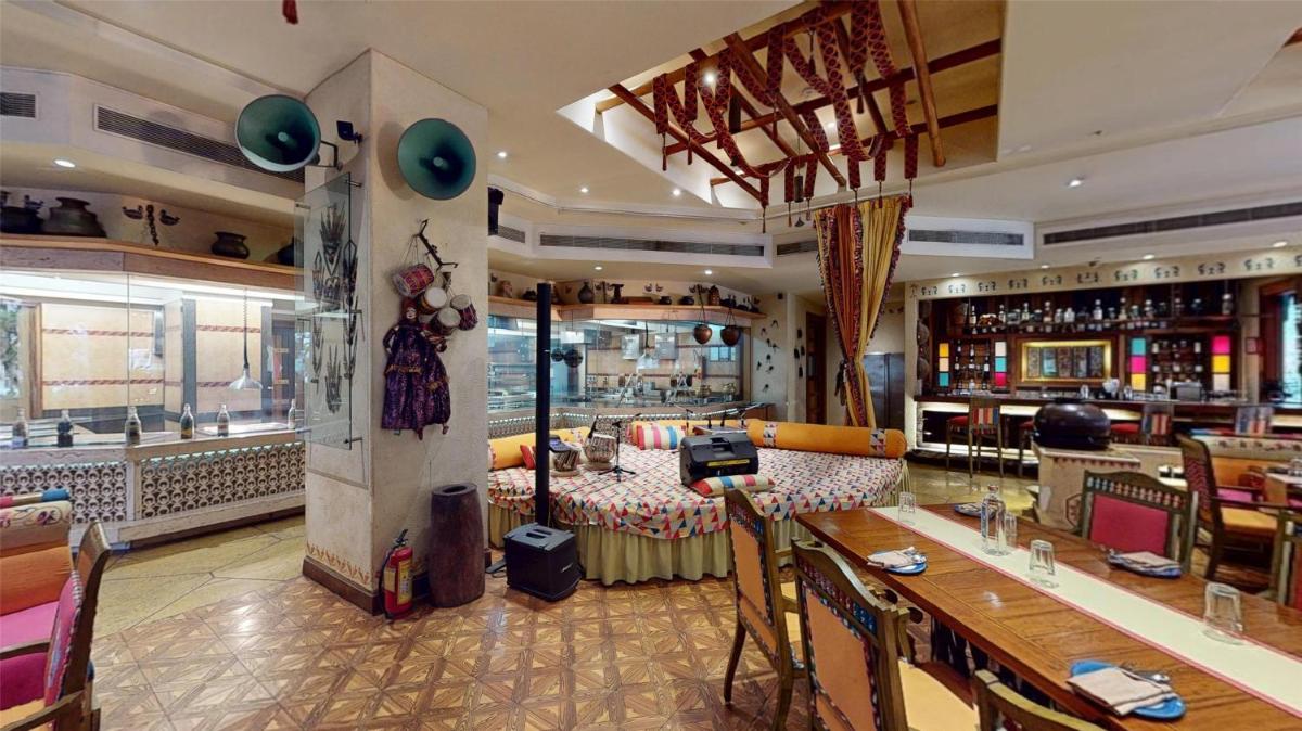 a restaurant with a long table and a bar at Radisson Blu Hotel, Nagpur in Nagpur