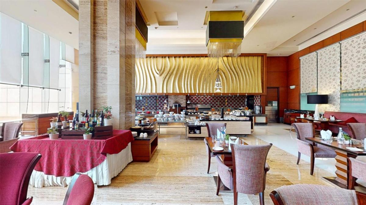 a dining room with tables and chairs and a restaurant at Radisson Blu Hotel, Nagpur in Nagpur