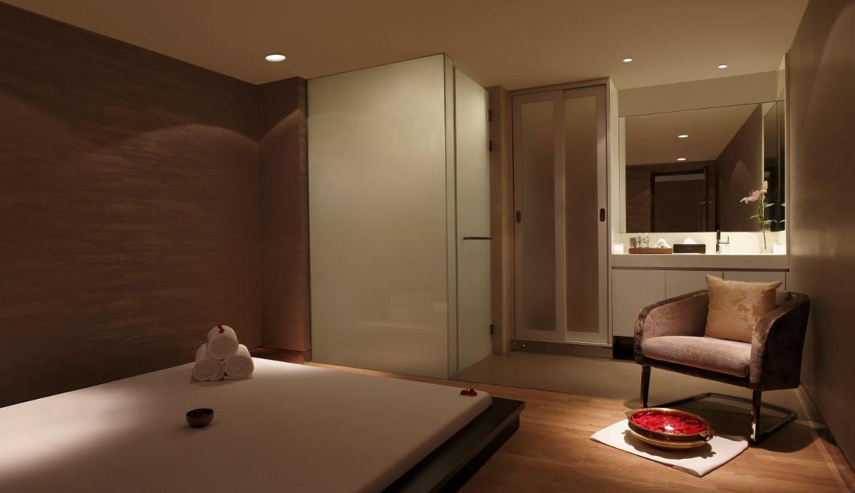 a bedroom with a bed and a chair and a mirror at Novotel New Delhi Aerocity in New Delhi