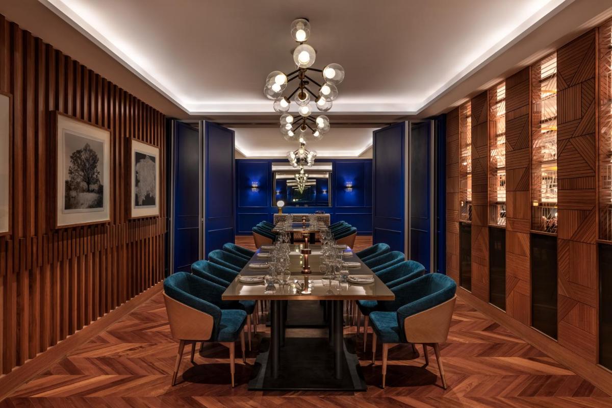 a dining room with a long table and blue chairs at JW Marriott Mumbai Juhu in Mumbai