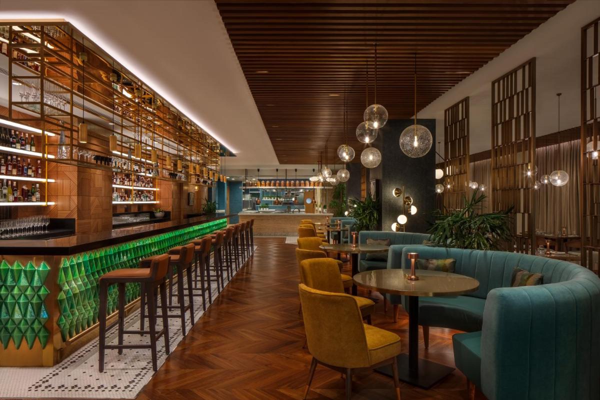 a restaurant with tables and chairs and a bar at JW Marriott Mumbai Juhu in Mumbai