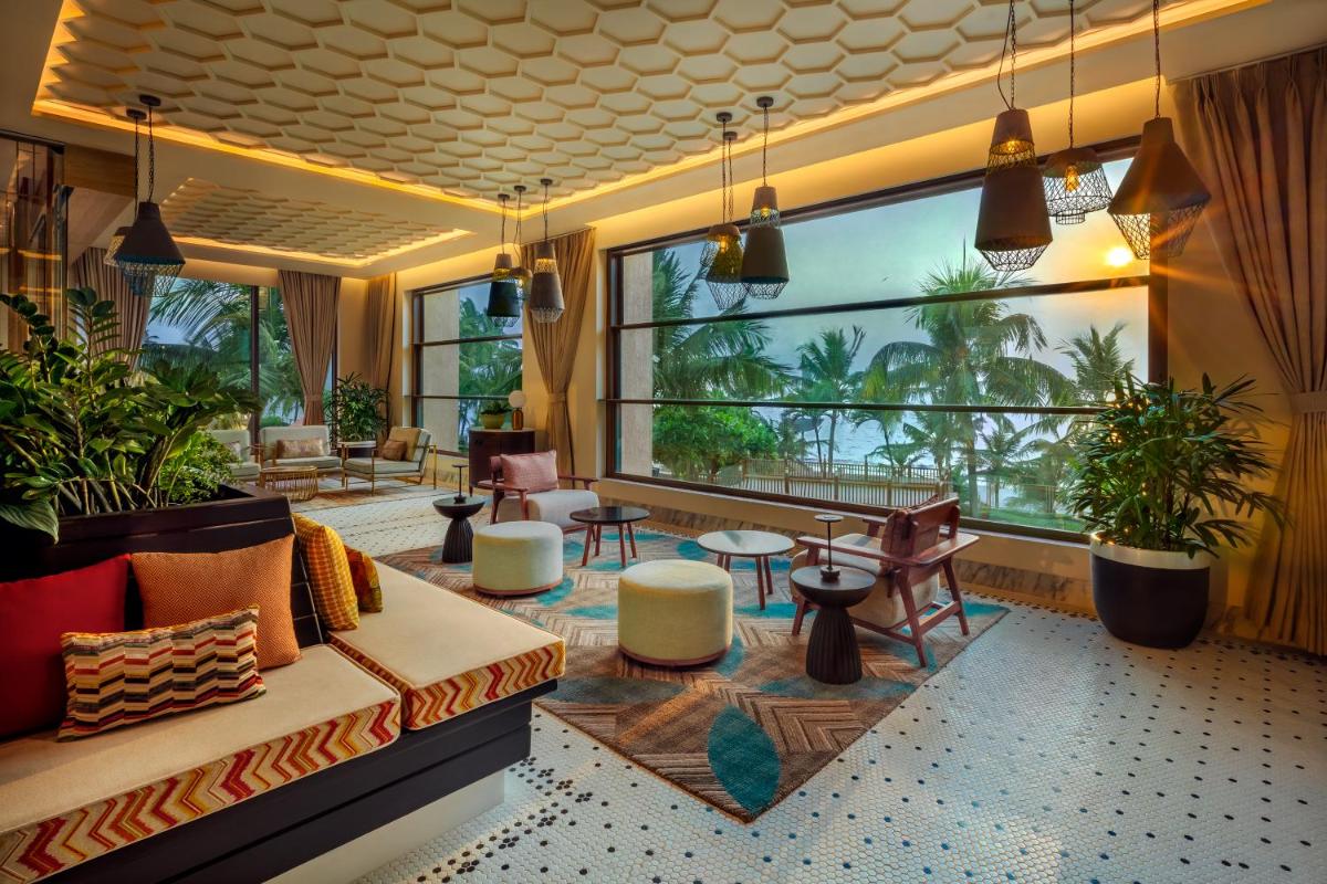a living room with a couch and a large window at JW Marriott Mumbai Juhu in Mumbai