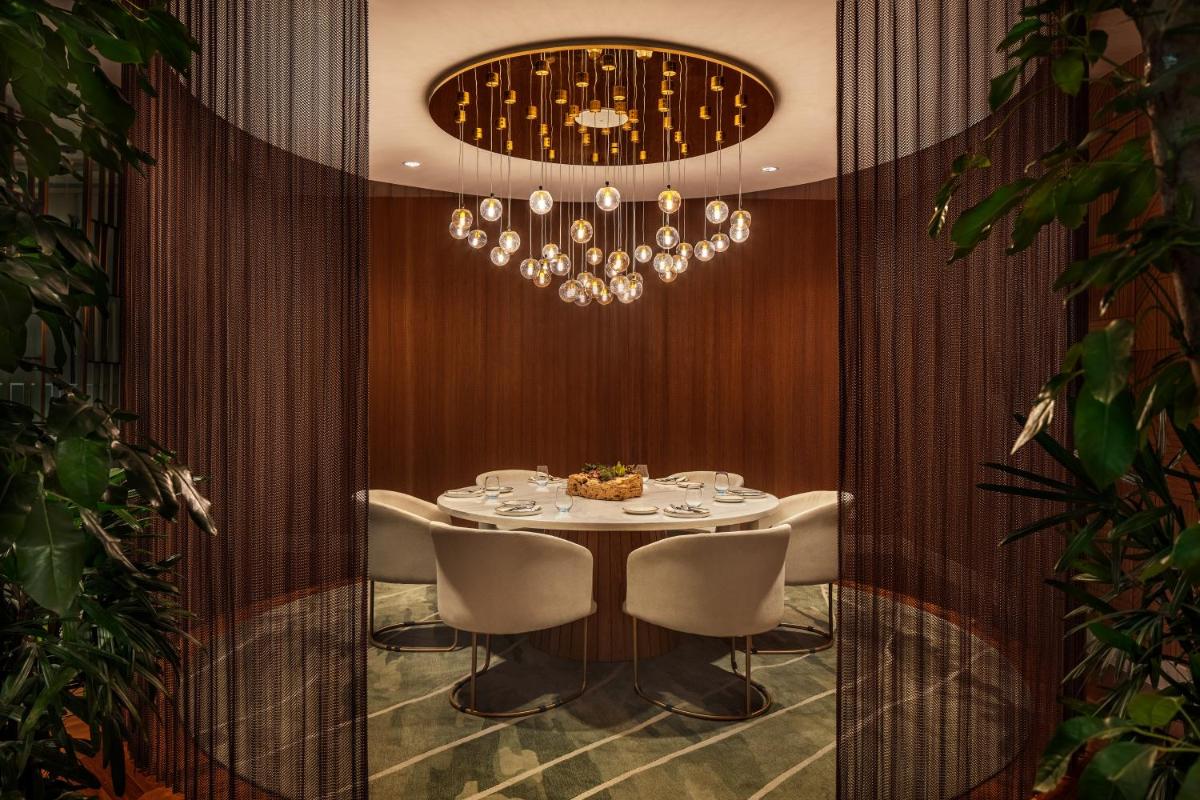 a dining room with a table and a chandelier at JW Marriott Mumbai Juhu in Mumbai